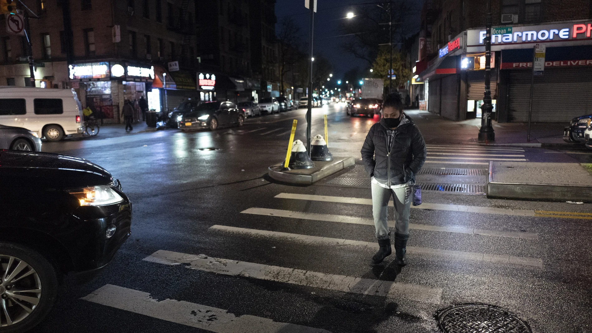 Una mujer camina de noche en Brooklyn por calles vacías a causa de la pandemia