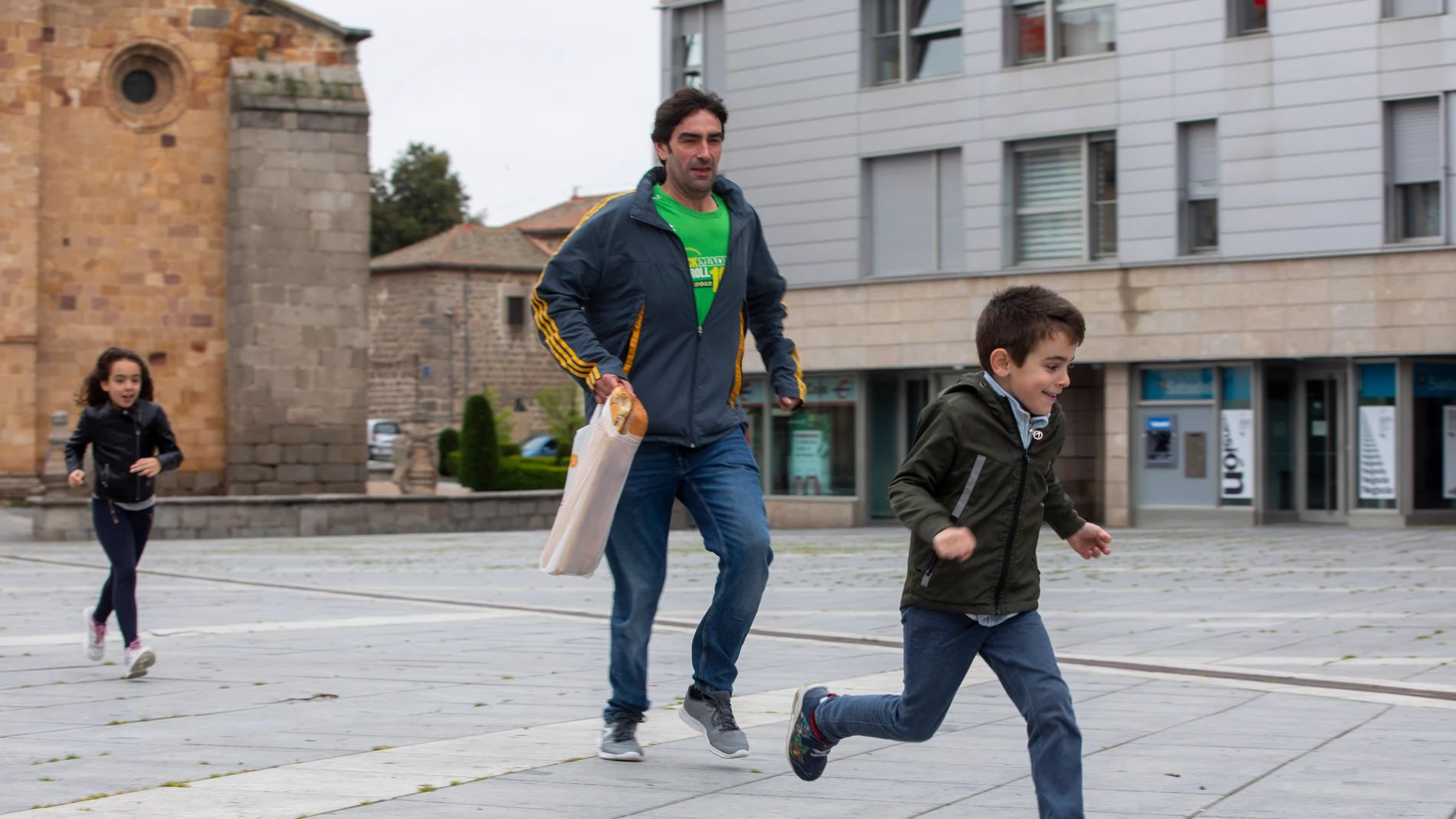 Tras varias semanas de confinamiento los niños pueden salir a pasear hasta una hora. En la foto Juan Simón, con sus hijos Simón y Jara, aprovechan para echar unas carreras en la Plaza de Santa Teresa de Ávila