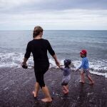 Una mujer con dos niños pasea ayer por la playa de Torre de Benagalbón en Rincón de la Victoria