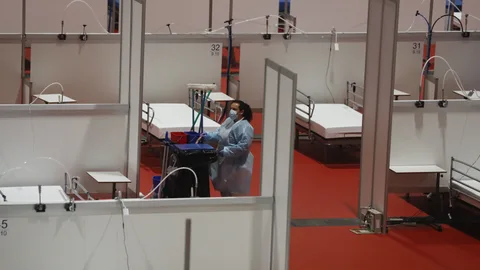 Una trabajadora limpia parte del pabellón 9 del hospital provisional de Ifema ya prácticamente vacío este martes en Madrid. Por el recinto, cuyas instalaciones se levantaron en un tiempo récord, han pasado cerca de 4.000 enfermos de coronavirus. EFE/ Ballesteros