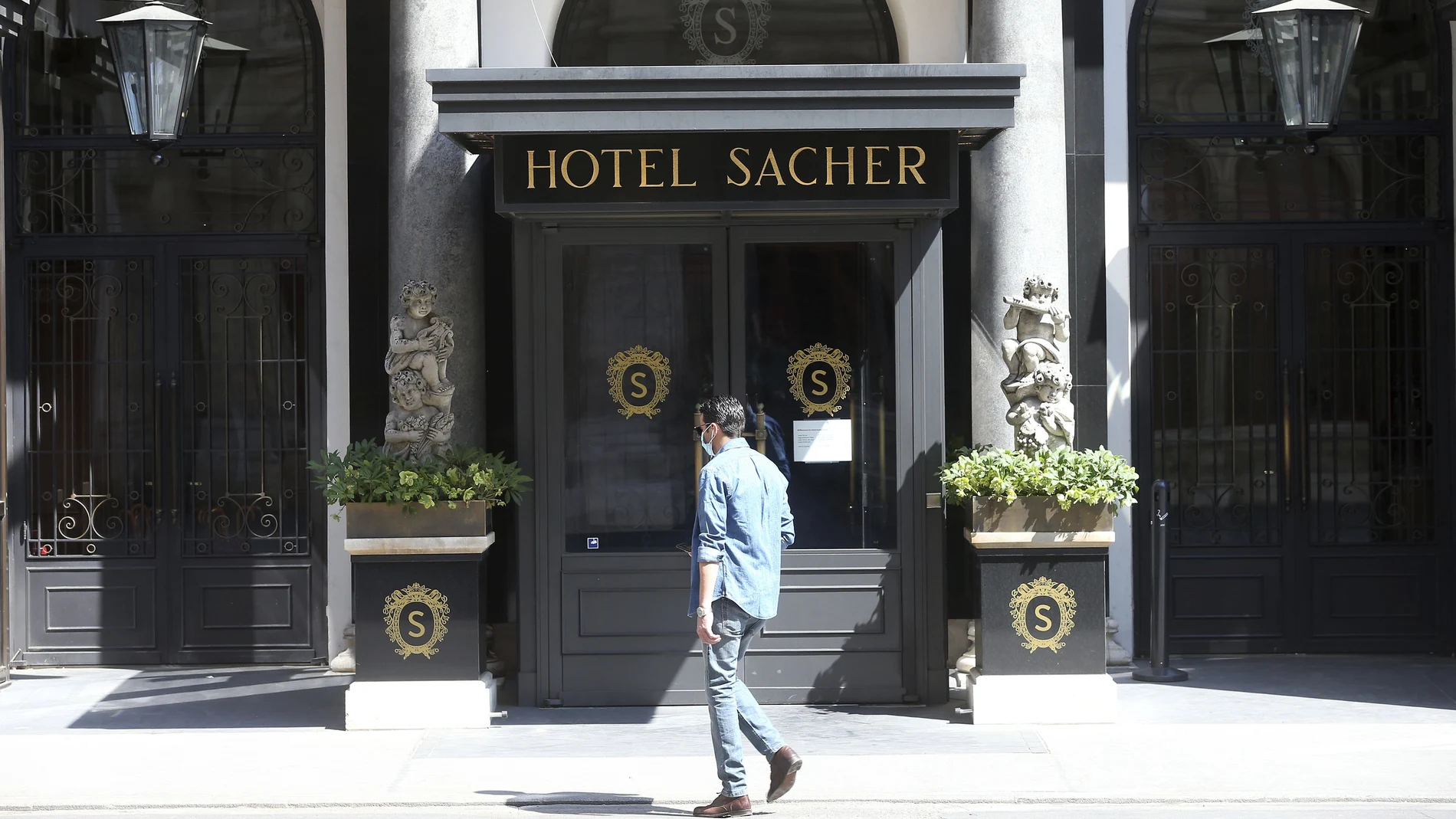 Un hombre con mascarilla frente al mítico hotel Sacher en Viena