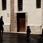 Un hombre pasea, por el centro de Valencia, junto a dos niños