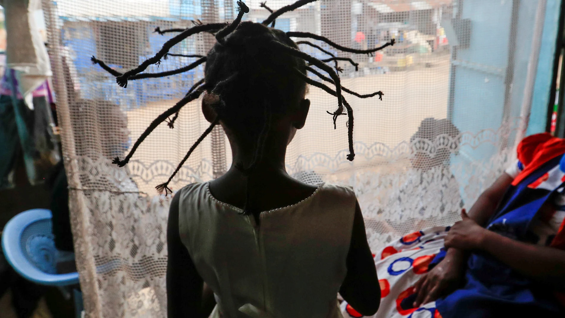 Stacy Ayuma is seen after plaiting with the "coronavirus" hairstyle, as a fashion statement against the spread of the coronavirus disease (COVID-19) in Kibera, Nairobi