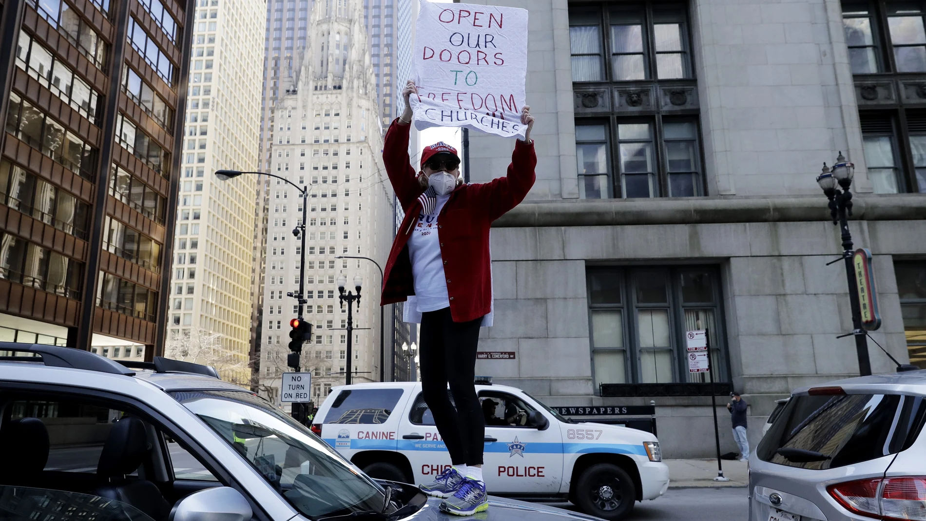 Una mujer protesta contra las órdenes de confinamiento sobre su coche en Chicago