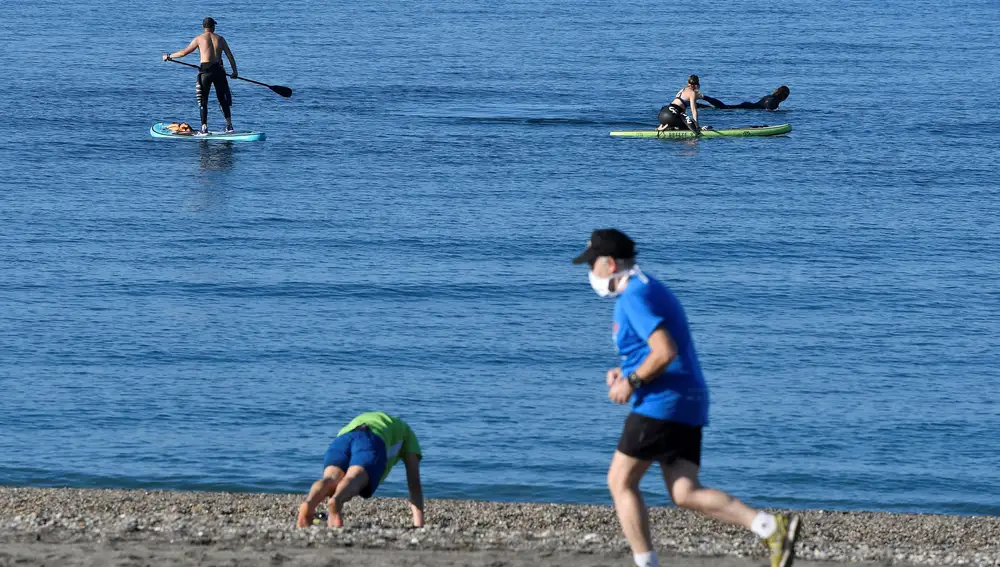 Varias personas practican deporte en la playa de El Zapillo de Almería