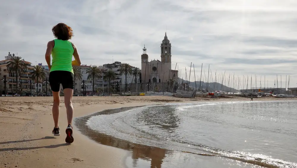 Una persona hace ejercicio en la playa de Sitges