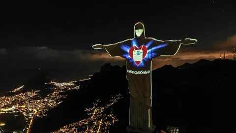 AME7461. RIO DE JANEIRO (BRASIL), 03/05/2020.- El Cristo Redentor de Río de Janeiro luce una máscara proyectada en su rostro para concienciar a la población de la importancia de su uso durante la pandemia de coronavirus este domingo, en Río de Janeiro (Brasil). EFE/Antonio Lacerda