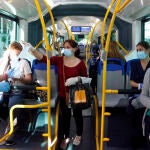 Miembros de protección civil de Málaga entregan mascarillas a los pasajeros de autobuses, durante la fase 0 de la desescalada del Gobierno en el inicio de la semana 8 del estado de alarma