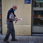 Un hombre camina con mascarilla leyendo un periódico durante el segundo día de la fase 0 de la desescalada y durante el periodo en el que la salida de mayores de 70 años se establece de 10 a 12 horas y de 19 a 20 horas, en Pamplona/Navarra (España) a 5 de mayo de 2020.