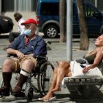 Dos personas toman el sol en el paseo marítimo de Barcelona, este miércoles, quincuagésimo tercer día del estado de alarma decretado por el Gobierno debido a la crisis sanitaria de la COVID-19. EFE/Toni Albir