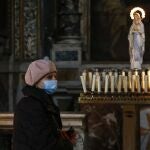 Una mujer con mascarilla en la iglesia de Maria ai Monti de Roma