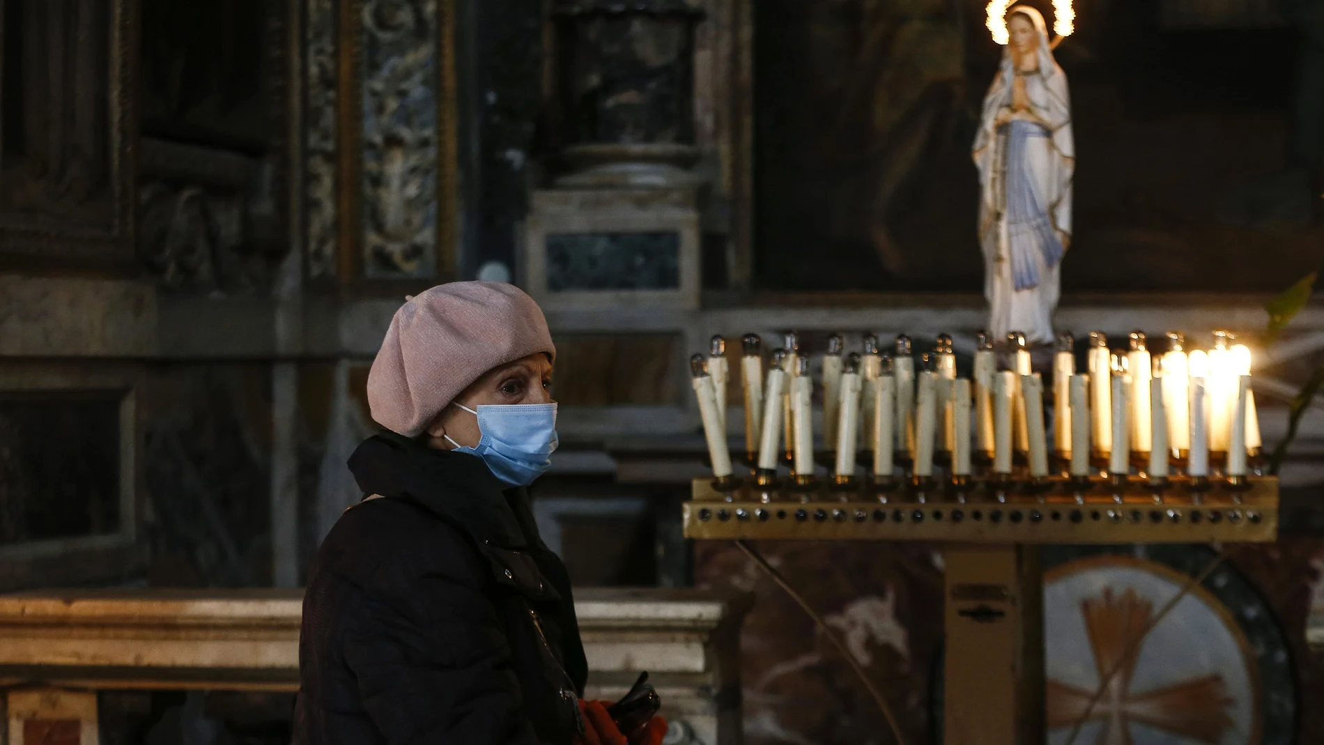 Una mujer con mascarilla en la iglesia de Maria ai Monti de Roma