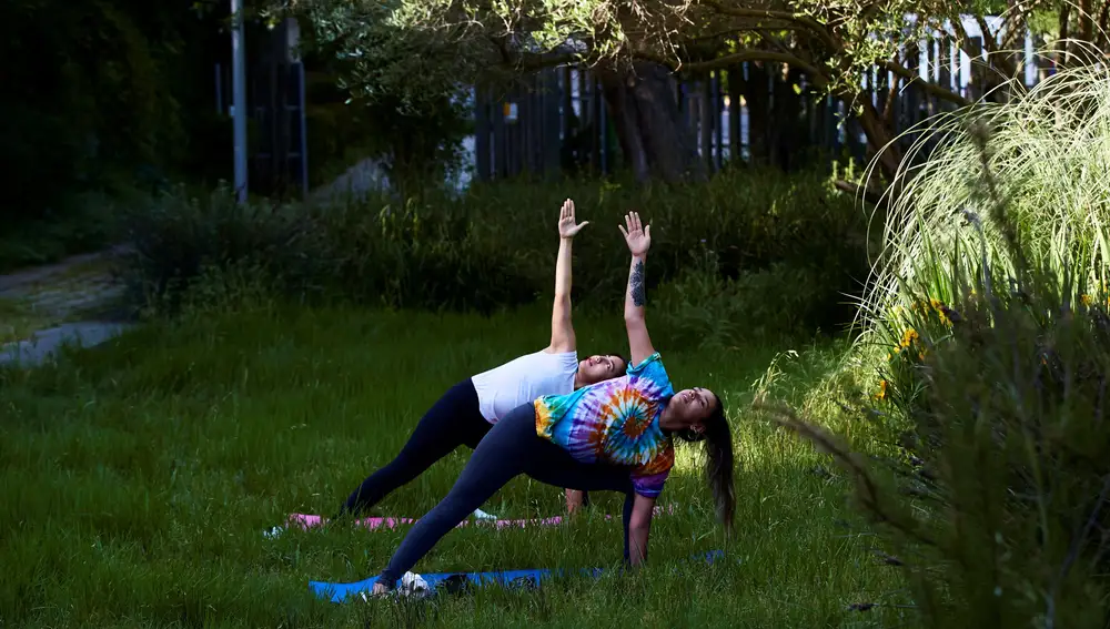 Dos personas practican yoga en el parque Joan Brossa, uno de los parques de la montaña de Montjuic que este viernes ha reabierto el Ayuntamiento de Barcelona. EFE/Alejandro García