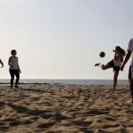 Un grupo juega en un rondo improvisado en la playa de la Barceloneta