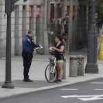 Un agente de la Policia Municipal de Madrid identifica a una ciclista fuera de la franja horaria a la que esta debe someterse, en la Puerta del Sol