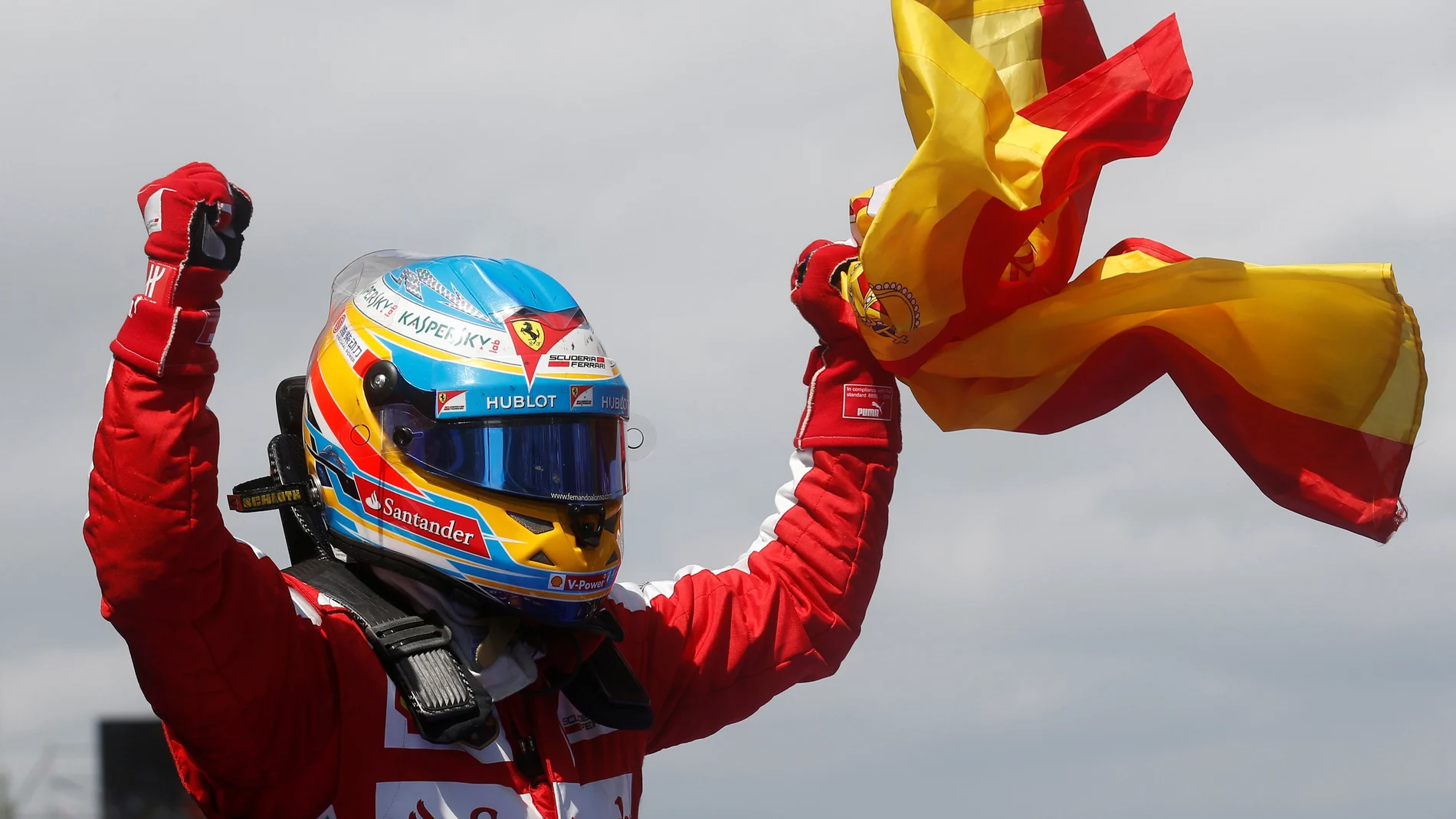 FILE PHOTO: Ferrari driver Fernando Alonso of Spain celebrates holding his national flag after winning the Spanish Grand Prix at the Circuit de Catalunya
