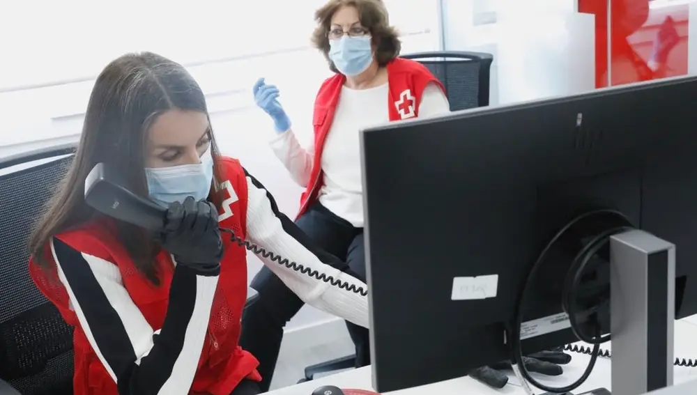 La Reina doña Letizia realiza llamadas telefónicas durante una jornada con voluntarios en un centro de Cruz Roja Española, en Madrid