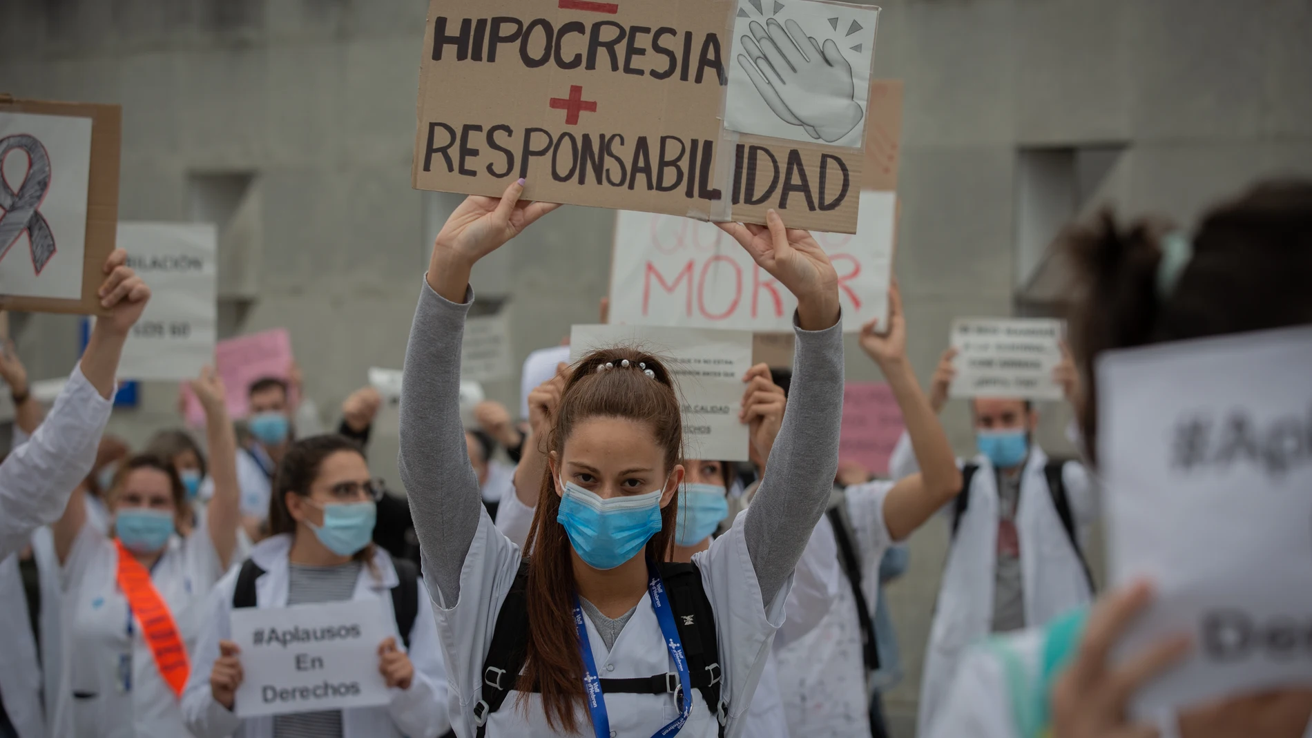 Una sanitaria sostiene un cartel que pide "Menos hipocresía y más responsabilidad", acompaña de decenas de miembros del personal sanitario protegidos con mascarilla, durante la concentración de sanitarios en el Día Internacional de la Enfermería a las puertas del Hospital Vall d'Hebron, en Barcelona (Catalunya, España), a 12 de mayo de 2020.12 MAYO 2020;BARCELONA;CATALUÑA;CONCENTRACION;ENFERMEROS;COVID-19David Zorrakino / Europa Press12/05/2020
