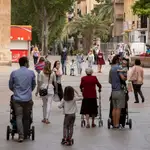 Varios padres y madres pasean con sus hijos por la plaza de Santo Domingo de Murcia