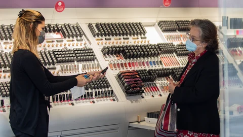 Una empleada de una tienda de cosmética atiende a una clienta durante el segundo día de la fase 1 del plan de desescalada que ha elaborado el Gobierno de España. En Sevilla, (Andalucía, España), a 12 de mayo de 2020.12 MAYO 2020María José López / Europa Press12/05/2020