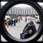 Un agente con mascarilla en la puerta de entrada del hospital de San Petersburgo que se ha incendiado