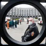 Un agente con mascarilla en la puerta de entrada del hospital de San Petersburgo que se ha incendiado