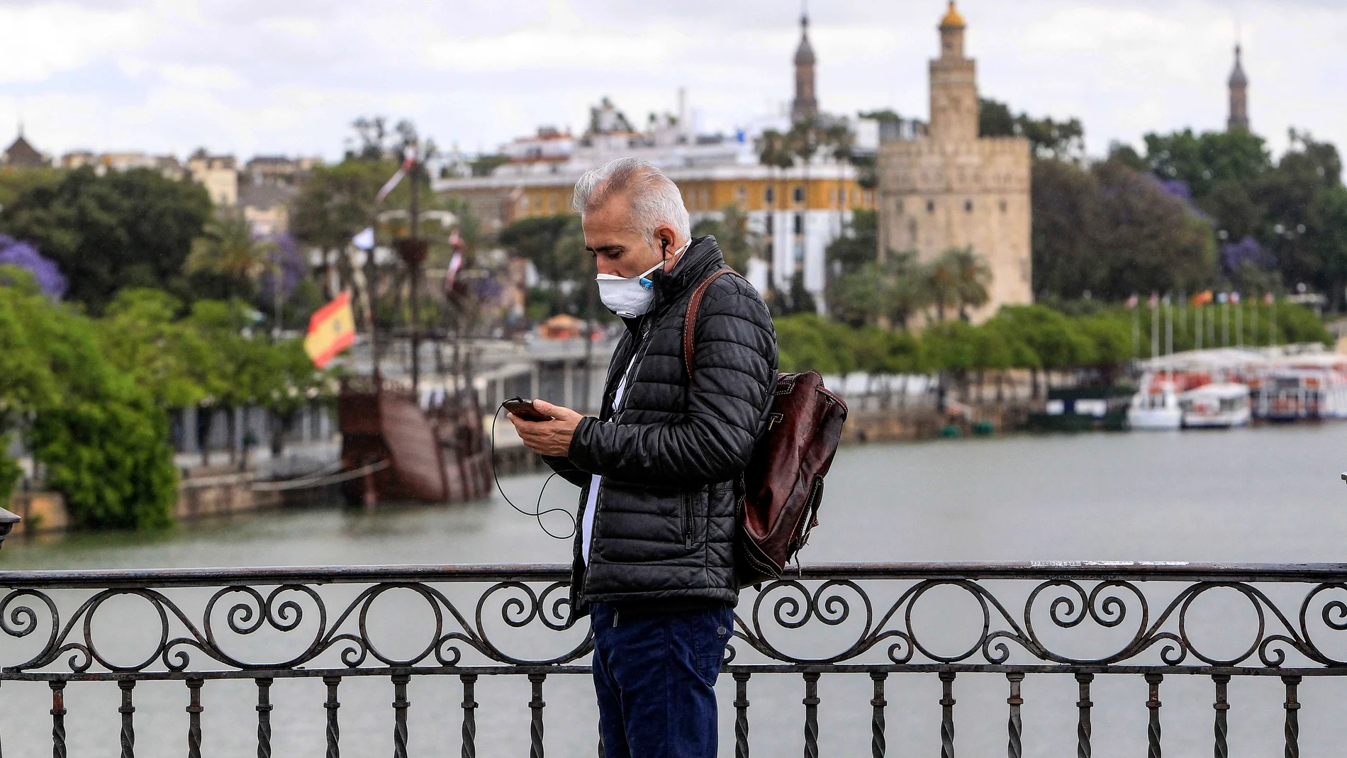 Un transeúnte por el puente de Triana en Sevilla