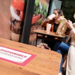 Varios clientes consumen en un establecimiento de Burger King, con mesas no disponibles para garantizar la separación