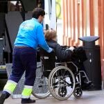 Un sanitario lleva a una anciana a la residencia dónde está alojada