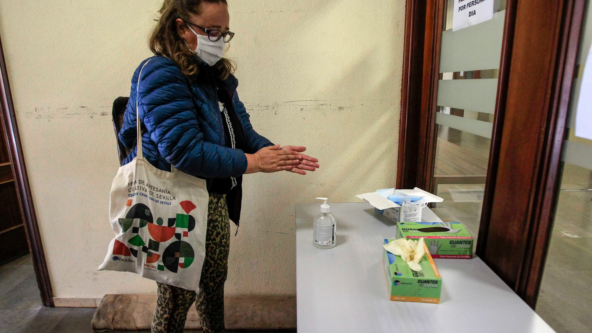 Una mujer se desinfecta las manos a la entrada de los juzgados de Sevilla