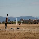 Una mujer hace ejercicio en la playa de La Patacona de Alboraya en el sexagésimo tercer día de estado de alarma