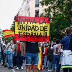 Un hombre sostiene una bandera de España durante una manifestación frente a la sede del PSOE en Madrid