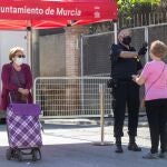 Un guardia de seguridad toma la temperatura a una mujer para garantizar la seguridad por la pandemia del covid-19, en la entrada del mercado semanal de la pedanía murciana de La Alberca, este lunes, octavo día de la fase 1 en la Región de Murcia.Marcial EFE/ Marcial Guillén