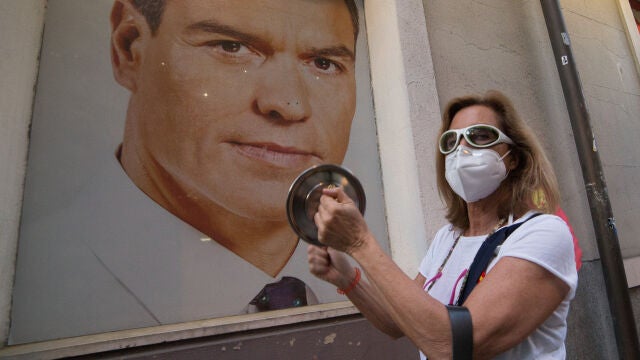 Una mujer golpea una cacerola ante la imagen de Pedro Sánchez en señal de protesta por la política del Gobierno