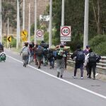 Fotografía del 13 de mayo que muestra a un grupo de migrantes venezolanos que camina por una carretera cercana a la frontera con Colombia, poco antes de introducirse en el bosque para cruzar el río Carchi
