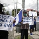SJS01-SAN JOSÉ (COSTA RICA) 18/5/2020- Nicaragüenses residentes en Costa Rica, se manifiestan con algunos carteles con mensajes alusivos contra el mandatario nicaragüense Daniel Ortega hoy lunes 18 de mayo, en las calles de San José. La Asociación Nicaragüense Pro Derechos Humanos (ANPDH) denunció este lunes que el Gobierno de Nicaragua está cometiendo un "genocidio viral" con la falta de medidas ante la pandemia del COVID-19, una situación ante la que la organización pidió la intervención de la Organización Mundial de la Salud. EFE/Jeffrey Arguedas