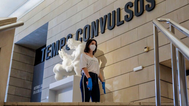 Una mujer protegida con guantes y mascarilla a la entrada de una exposición en el Museo Institut Valencià d'Art Modern (IVAM)