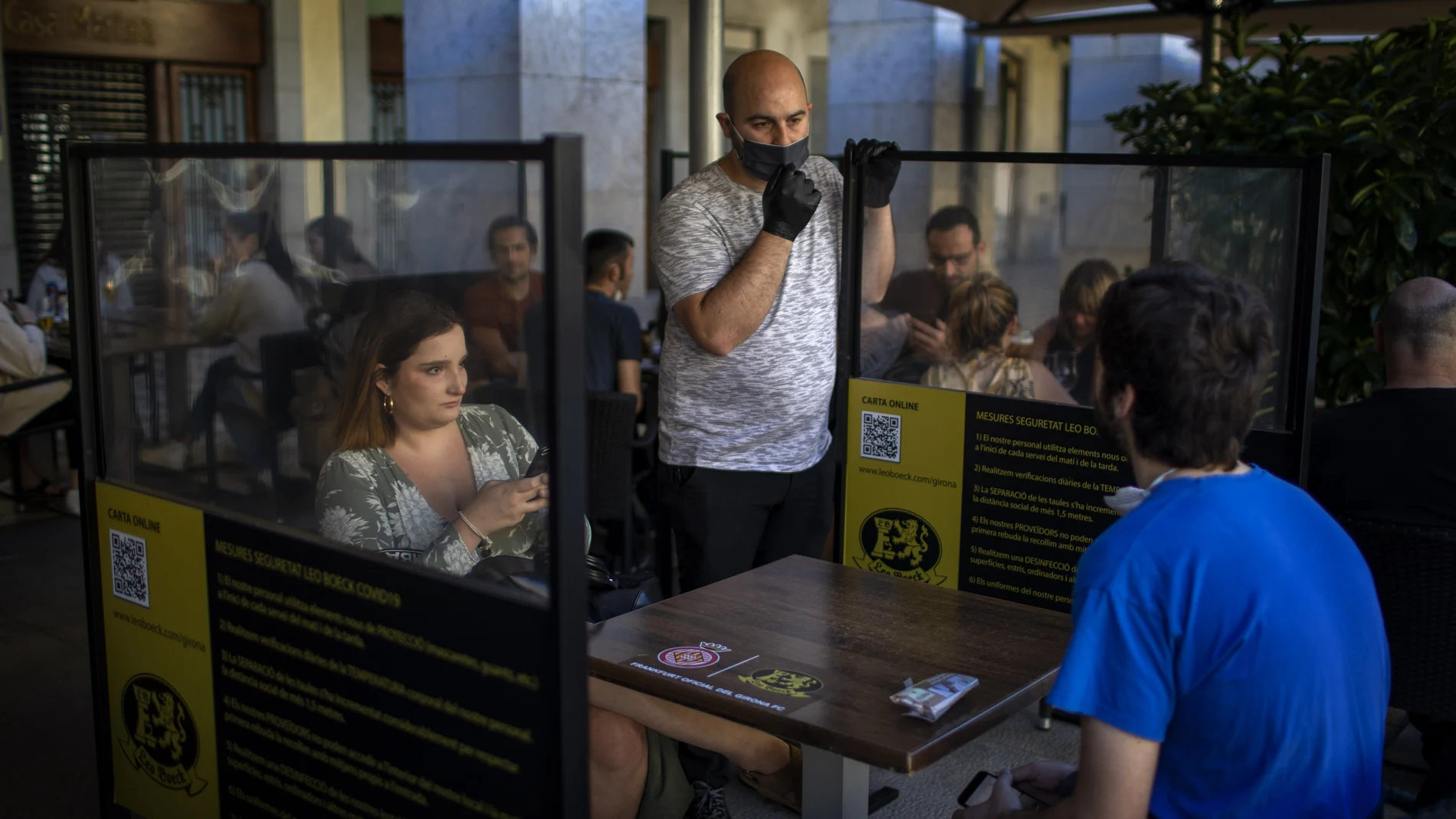 La mesa de una terraza de Gerona protegida con mamparas
