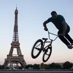 Un ciclista hace algunas acrobacias en la Plaza de los Derechos Humanos de Trocadero, cerca de la Torre Eiffel, este lunes, en París (Francia).