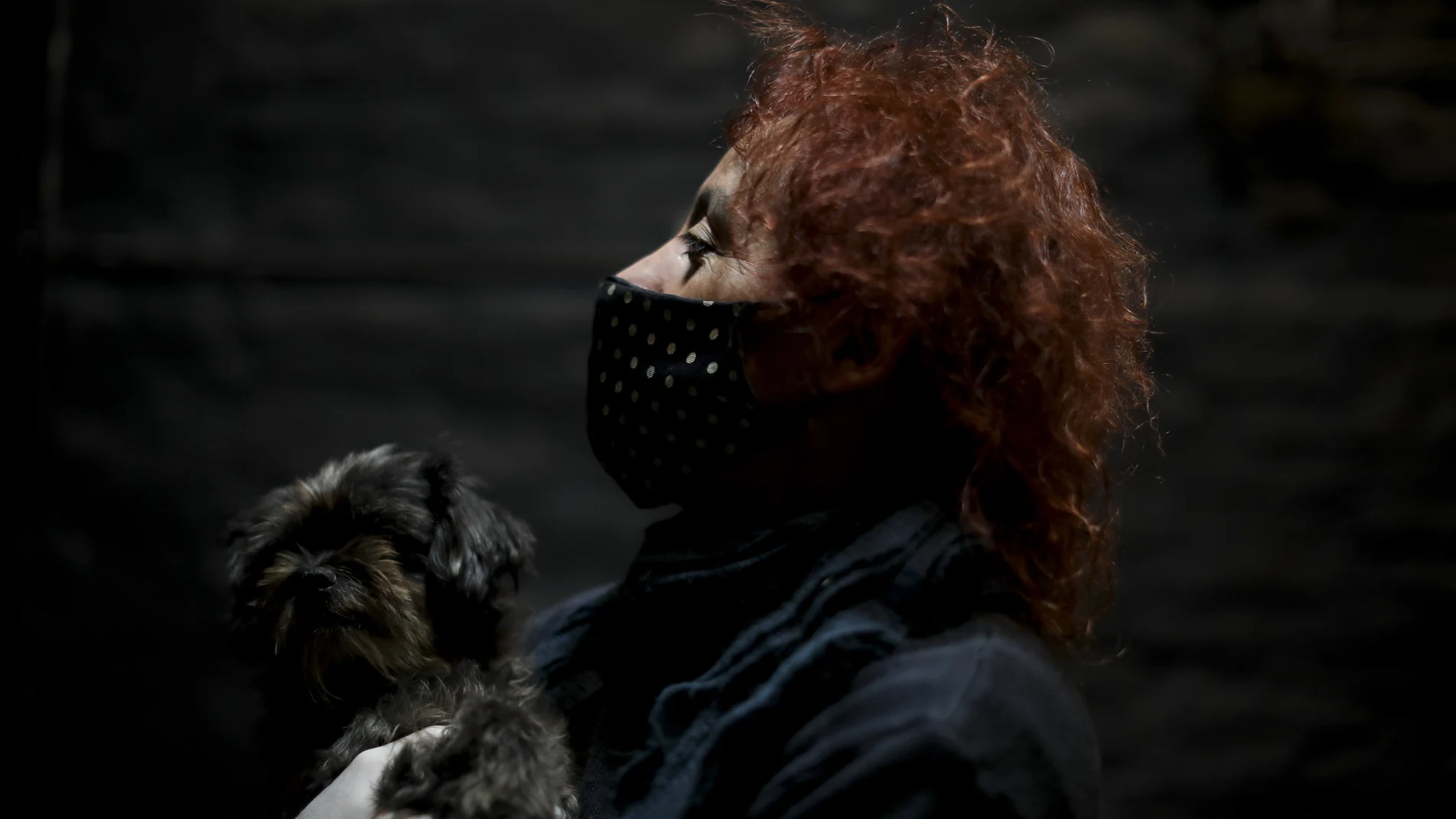 Actor Fabio "Mosquito" Sancineto poses with her dog for a portrait inside a closed theater in Buenos Aires, Argentina, Saturday, May 16, 2020. Sancineto is the promoter of Solidarity Artists, an initiative to help fellow artists struggling to eat and pay bills after months without work after hundreds of theaters were closed by the mandatory lockdown to stop the spread of the new coronavirus. (AP Photo/Natacha Pisarenko)