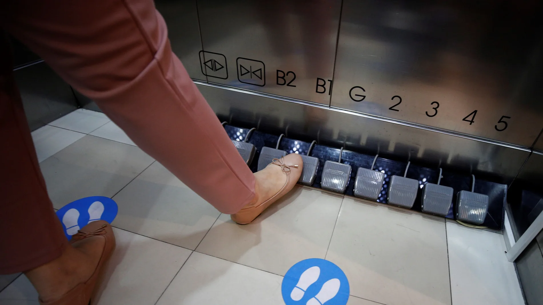 -FOTODELDIA- Bangkok (Tailandia), 20/05/2020.- Una clienta selecciona con el pie el piso al que se dirige en un ascensor del centro comercial Seacon Square de Bangkok (Tailandia) este miércoles. Los ascensores han sido modificados para evitar la propagación del COVID-19. EFE/Narong Sangnak