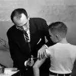 Jonas Salk vacunando a un niño por la polio