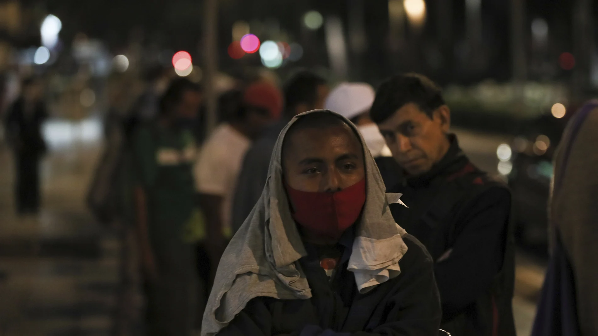 Homeless and unemployed wearing masks against the spread of the new coronavirus lineup to receive a free meal in Mexico City, Wednesday, May 20, 2020. The volunteers running the soup kitchen say they have had to expand their service from a single day to two days per week as the number of people in need grows. (AP Photo/Fernando Llano)