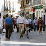 Sevillanos paseando por el centro, ayer, primer día de uso obligatorio de las mascarillas