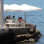 Varias mesas ocupadas en una terraza cerca del mar en un restaurante de Málaga que reabre sus puertas en la fase 1 en la que se encuentra esta provincia durante el estado de alarma debido a la crisis sanitaria de la COVID-19. EFE/Daniel Pérez