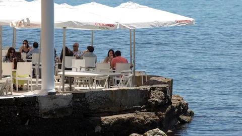 Varias mesas ocupadas en una terraza cerca del mar en un restaurante de Málaga que reabre sus puertas en la fase 1 en la que se encuentra esta provincia durante el estado de alarma debido a la crisis sanitaria de la COVID-19. EFE/Daniel Pérez