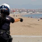 Una agente de la Policía Nacional realiza labores de control en la playa de la Malvarrosa