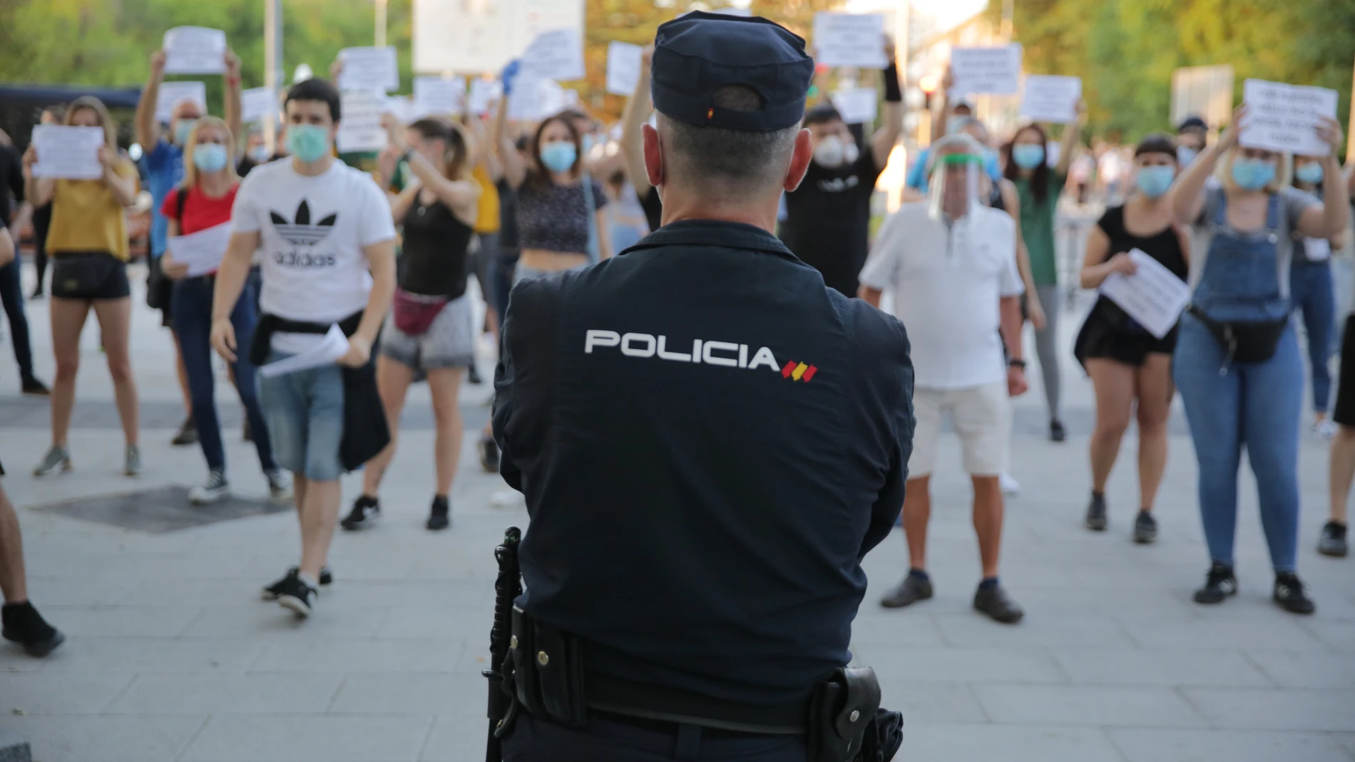Un policía separa a un grupo de manifestantes radicales de izquierda de una protesta contra el Gobierno en el barrio madrileño de Moratalaz
