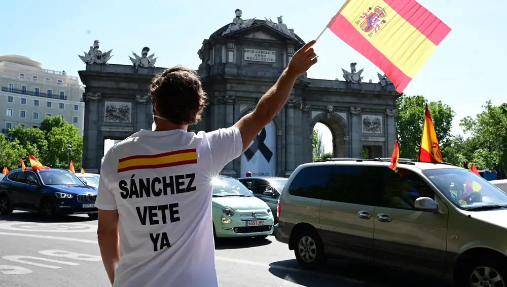 Manifestación en coche promovida por Vox. Algunos viandantes portan banderas y camisetas con el lema "Sánchez, vete ya"
