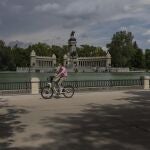 Un hombre pasea en bicicleta por El Retiro